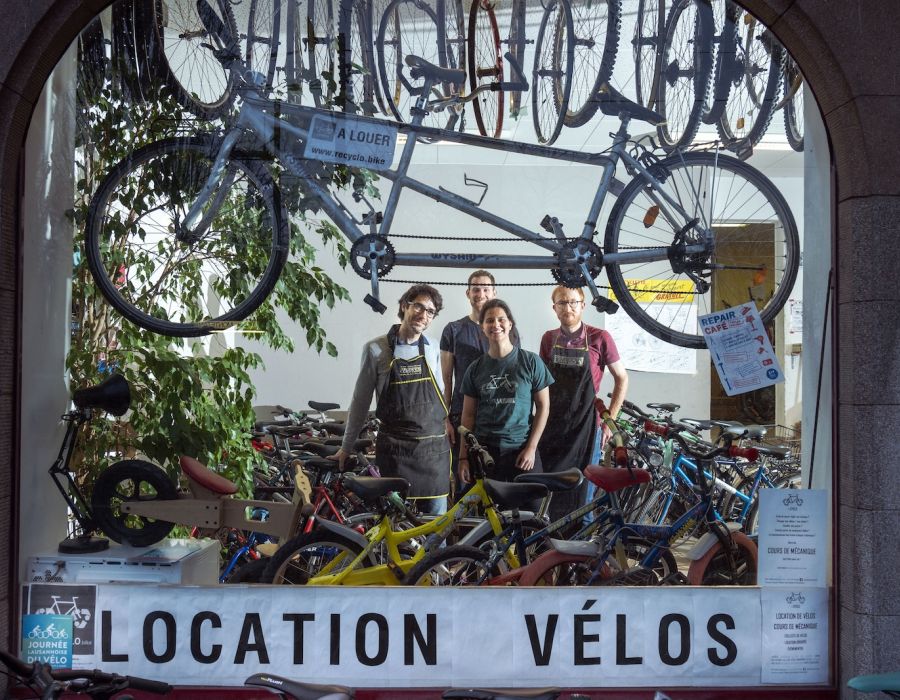 Devanture de "Recyclo" avec bénévoles et vélos.
