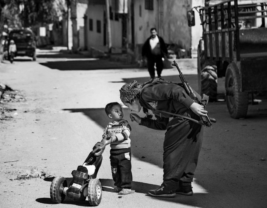 Photo de l'exposition avec une combattante kurde et un enfant.