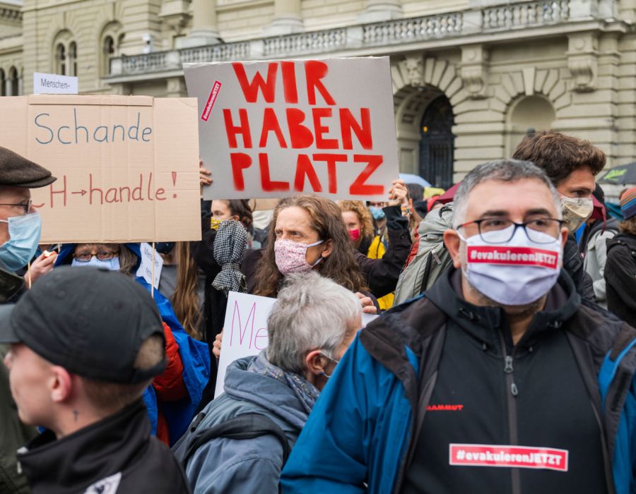Manifestation à Berne avec une pancarte "Nous avons de la place" en allemand.