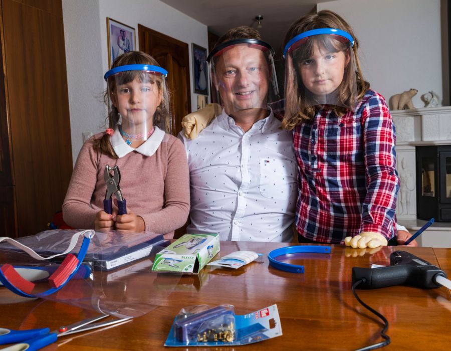 Dejan Adzijoski et ses deux fillettes, entourés de leur matériel de travail et visières sur la tête.