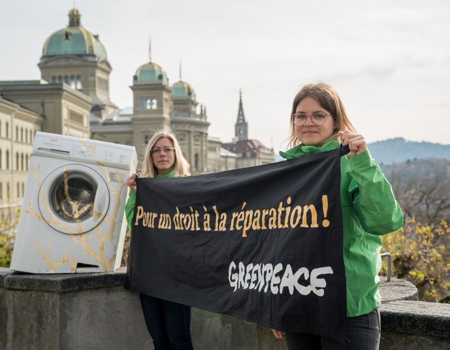 Des militantes de Greenpeace devant le palais fédéral avec une banderole "Pour un droit à la réparation".
