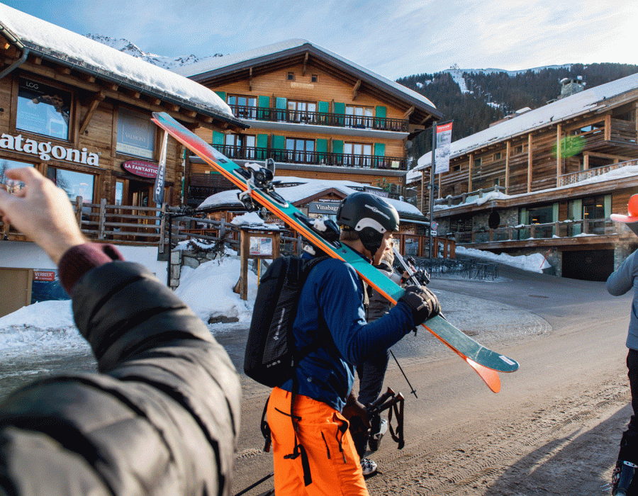 Des skieurs, skis sur l'épaule, dans les rues de Verbier.