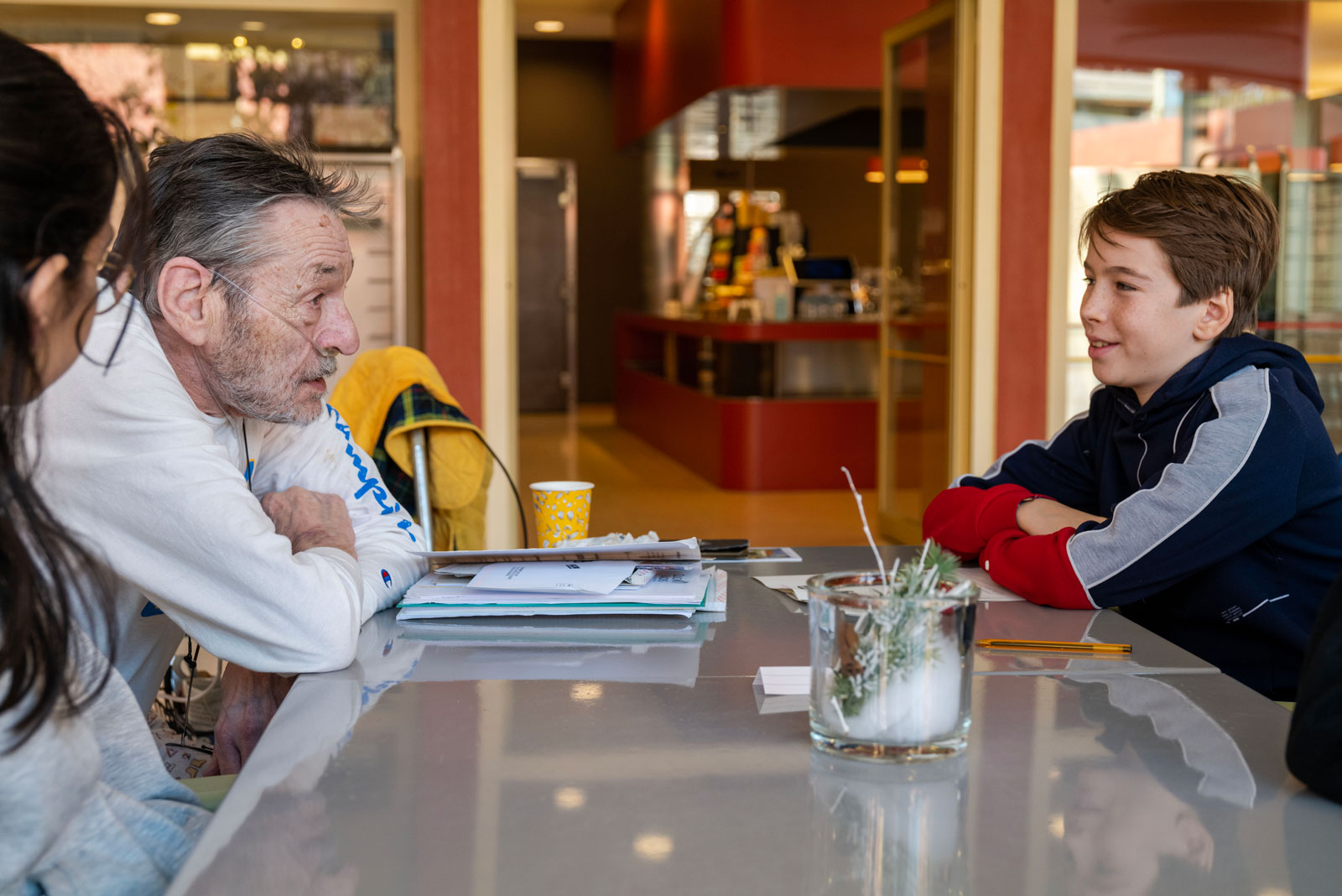 Un vieil homme s'entretient avec des adolescents.