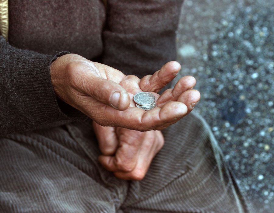 Main de mendiant avec deux pièces de monnaie.