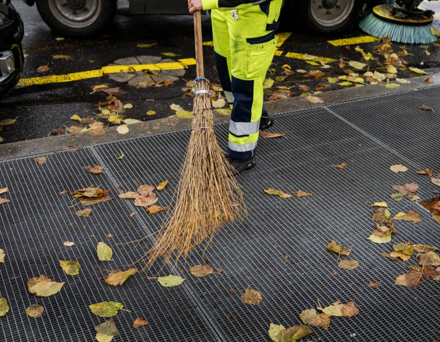 employée de voirie qui passe le balais