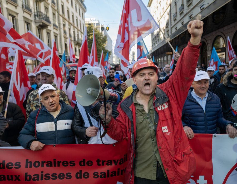 Manifestants à Genève avec des banderoles et des drapeaux Unia.