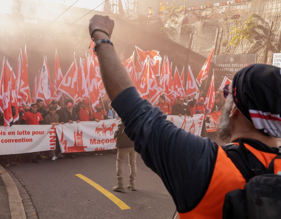 manifestants et une personne avec le poing levé.