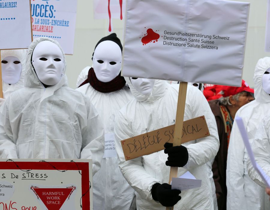 Manifestation devant Hilcona avec un panneau sur lequel on peut lire "destruction santé suisse".