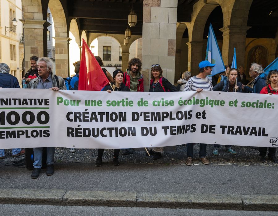 Des militants en faveur de l'initiative. Une banderole: Pour une sortie de crise écologique et sociale: création d'emplois et réduction du temps de travail.