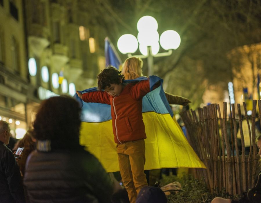 Un enfant porte un drapeau ukrainien.