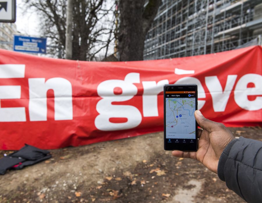 Téléphone avec application Uber, devant une banderole "En grève".