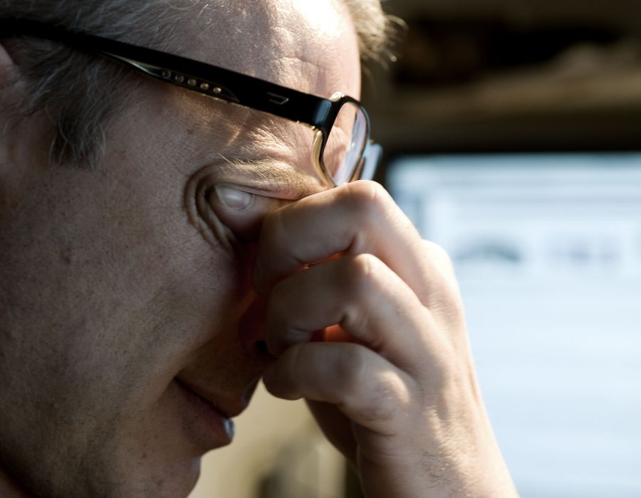 Homme fatigué qui se frotte les yeux.