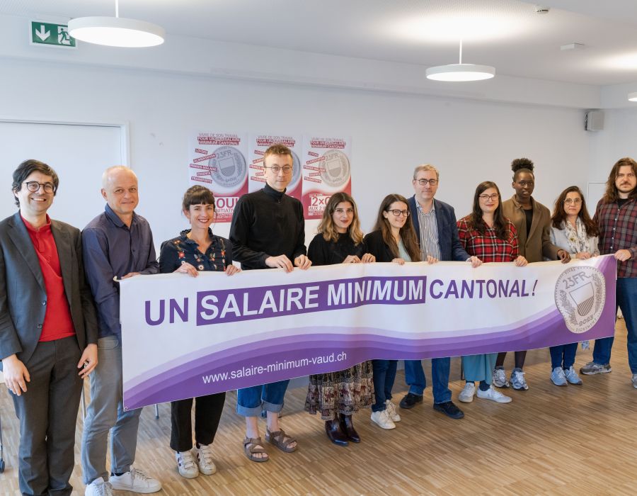 Comité unitaire pour salaire minimum Vaud derrière banderole.