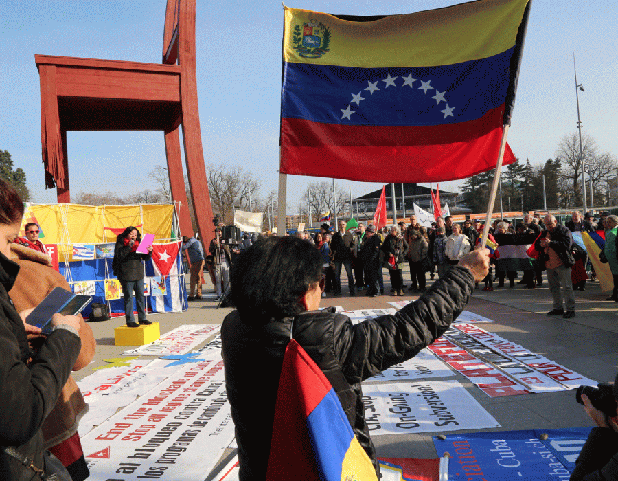 Des manifestants devant le Palais des nations brandissant un drapeau du Venezuela.